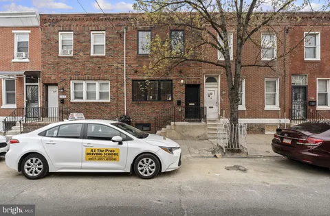 a car parked in front of a brick house
