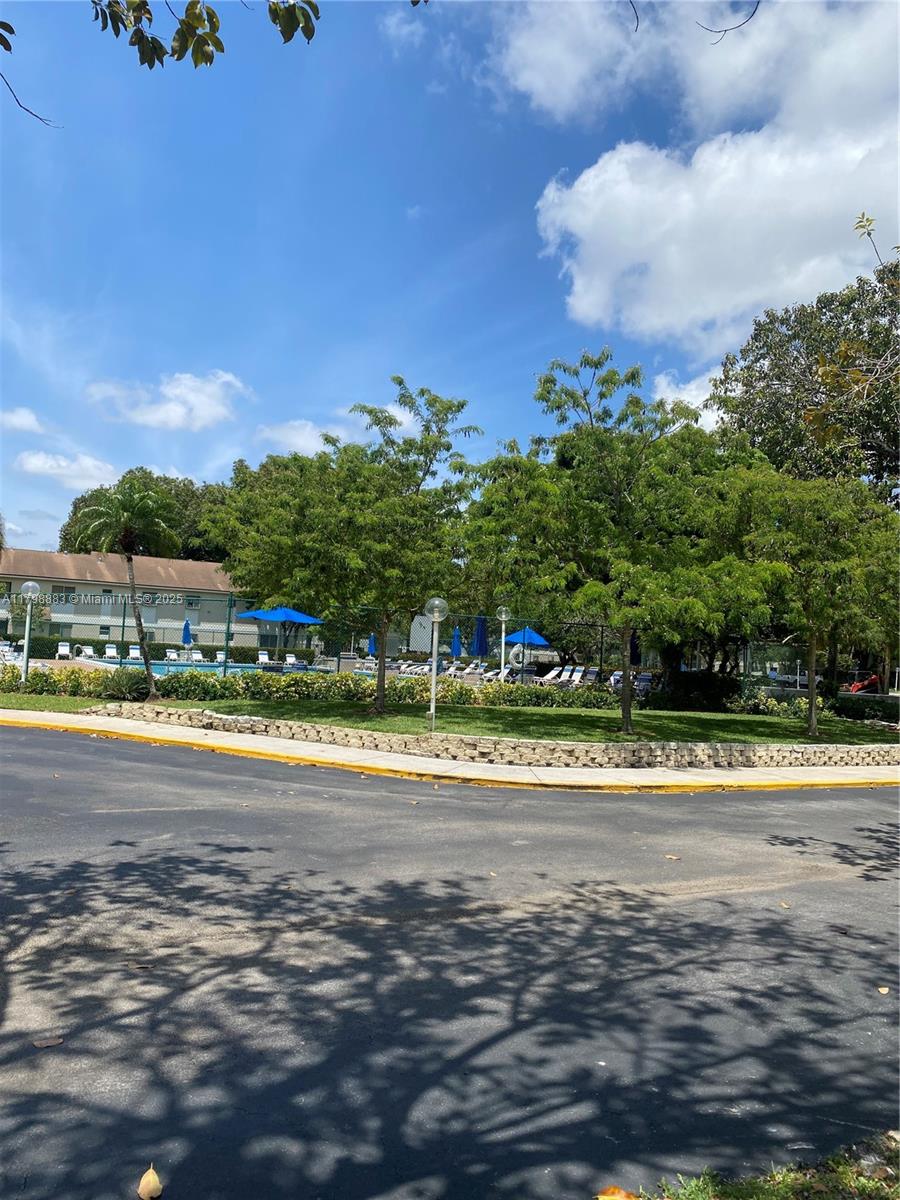 Gardens North Condominium Pompano Beach, FL 33069 - Photo 28 of 31 a view of a swimming pool and trees in the background
