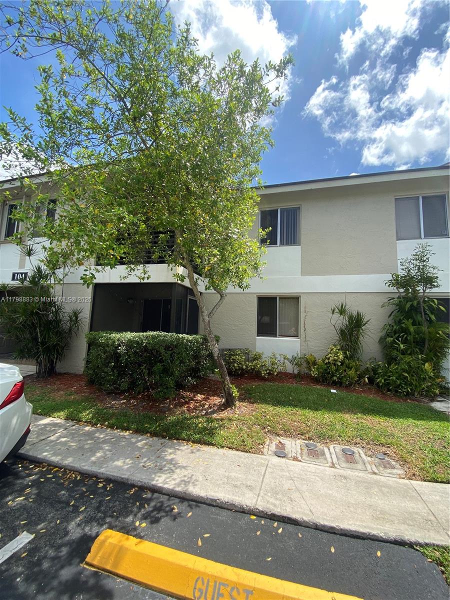 Gardens North Condominium Pompano Beach, FL 33069 - Photo 3 of 31 a front view of a house with a yard and garage
