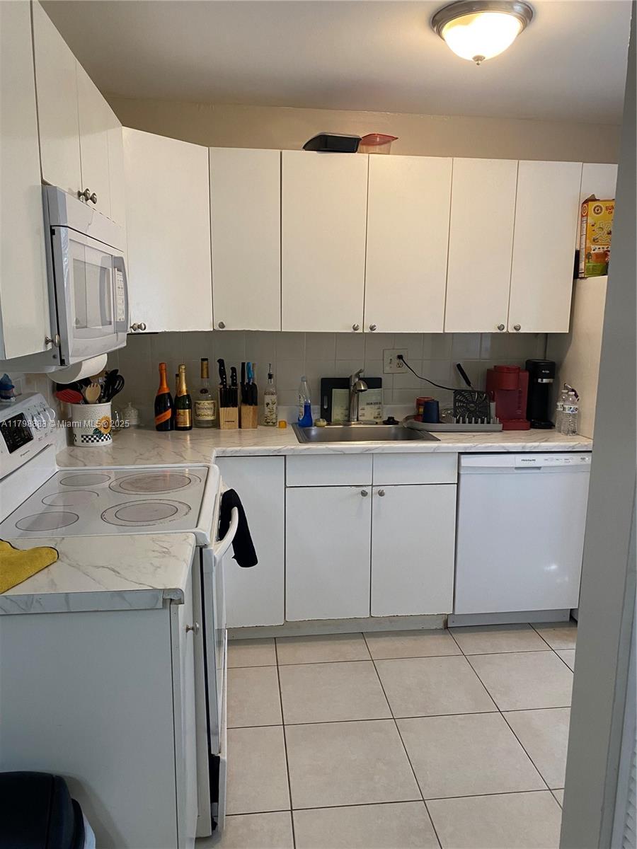 Gardens North Condominium Pompano Beach, FL 33069 - Photo 10 of 31 a kitchen with stainless steel appliances granite countertop a sink a stove and cabinets