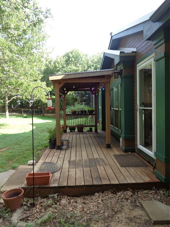 5525 Cedar Oaks Road Grandview, TX 76050 - Photo 3 of 40 Expansive wood plank deck with a built-in covered pergola and architectural wood railing