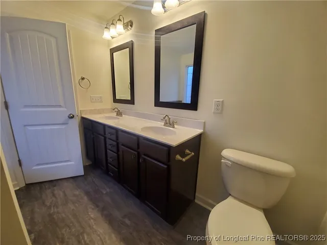 a bathroom with a granite countertop toilet sink and mirror