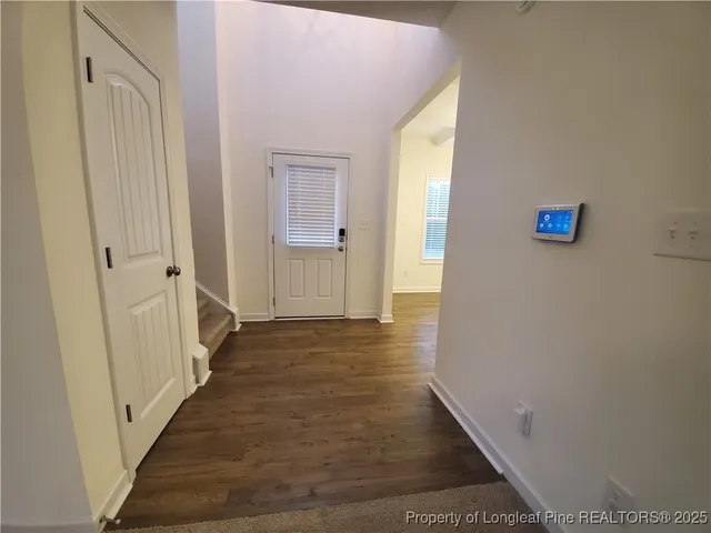 a view of a hallway with wooden floor and staircase