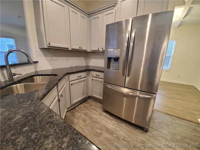 a kitchen with stainless steel appliances granite countertop a refrigerator sink and cabinets