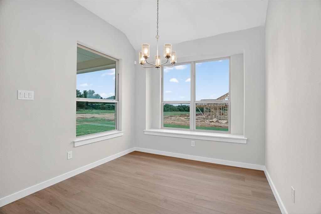 321 Skeen Peak Springtown, TX 76082 - Photo 15 of 37 Bright interior room featuring wood-finish flooring, white baseboards, and light neutral wall paint