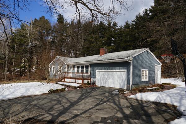 245 Harvard Road Stow, MA 01775 - Photo 3 of 12 a front view of a house with a yard covered with snow and trees