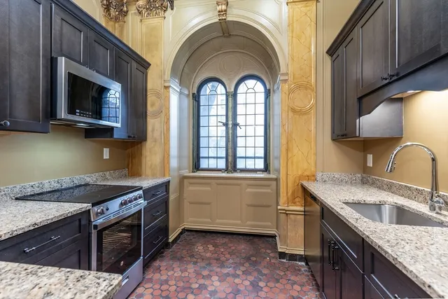 a view of a house with large windows and plants