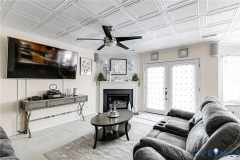a living room with furniture a flat screen tv and a fireplace