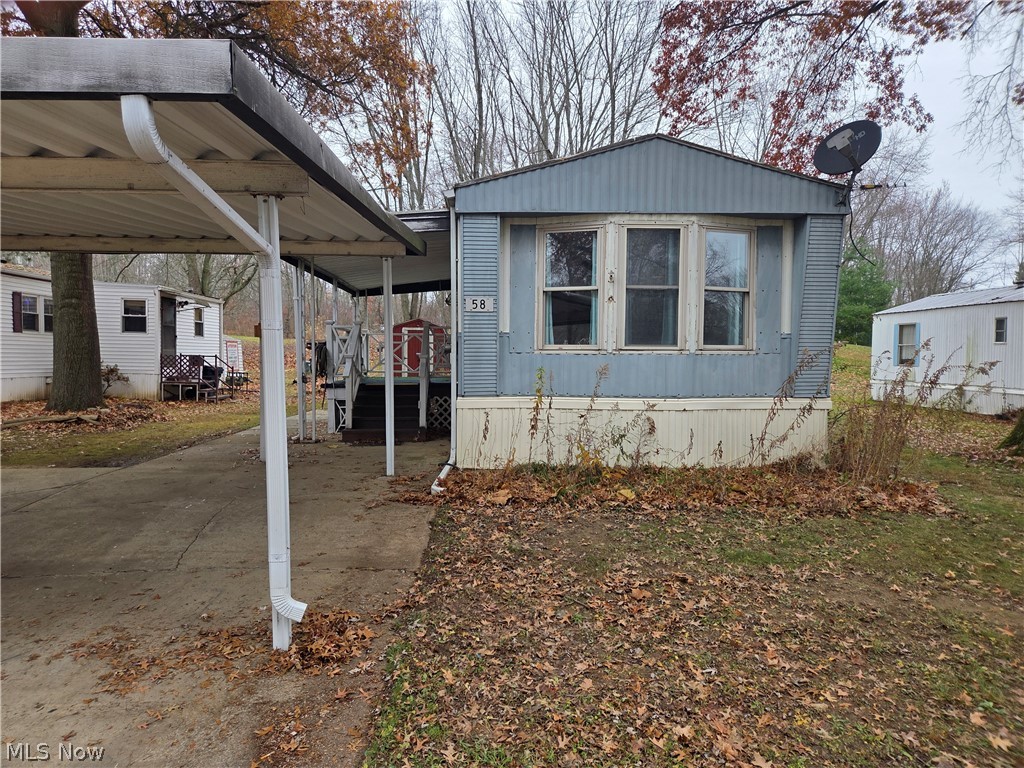 7443 Spillway Road, Unit 58 Lisbon, OH 44432 - Photo 1 of 15 View of property exterior with a carport and a wooden deck