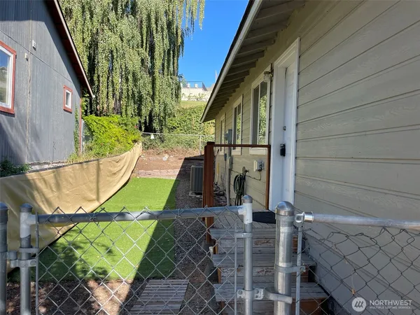 a backyard of a house with fountain table and chairs