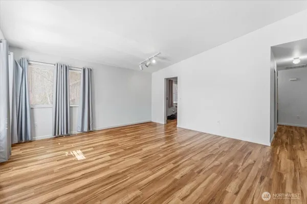 a living room with furniture flat screen tv and wooden floor
