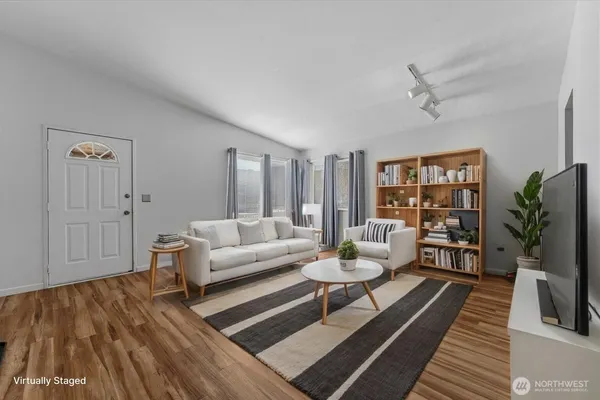 a view of a bedroom with wooden floor and windows
