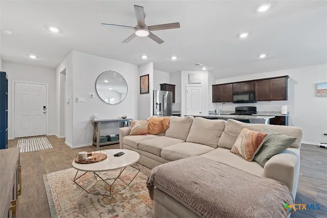 a living room with furniture kitchen view and a chandelier