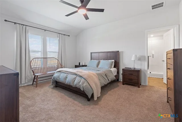 a bed sitting in a spacious bedroom next to a window