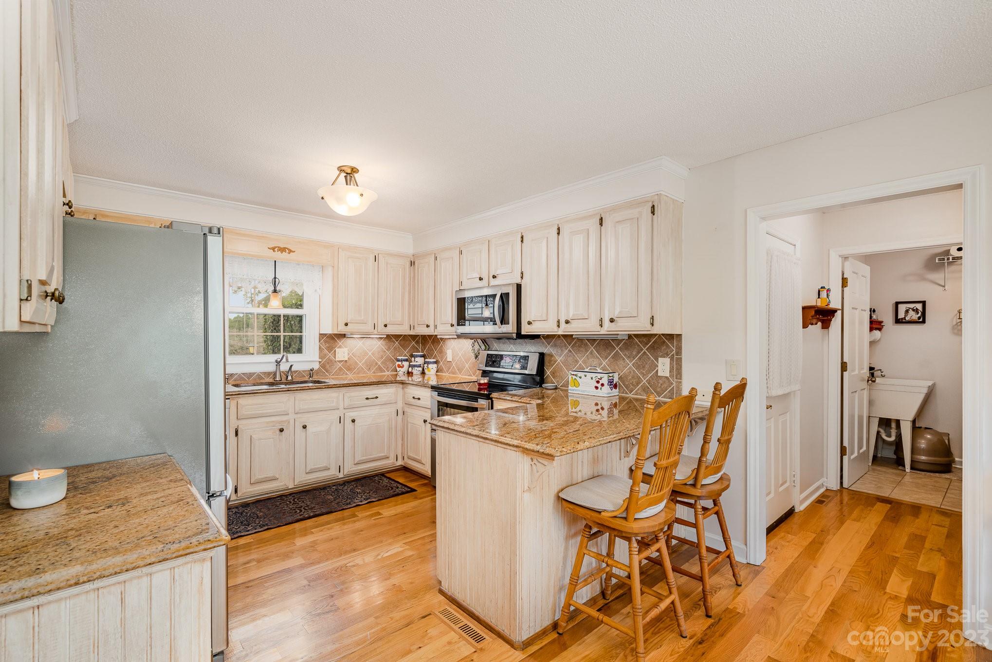 8229 Fairfield Forest Road Denver, NC 28037 - Photo 12 of 41 a kitchen with stainless steel appliances granite countertop a table chairs sink and cabinets