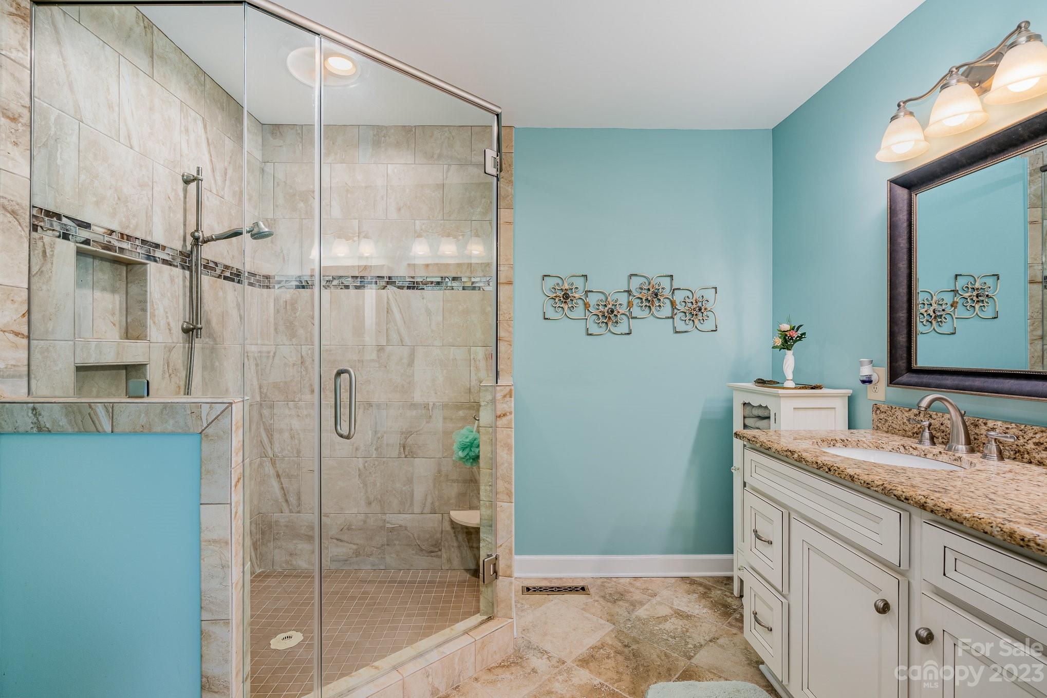 8229 Fairfield Forest Road Denver, NC 28037 - Photo 26 of 41 a bathroom with a granite countertop sink a mirror and shower