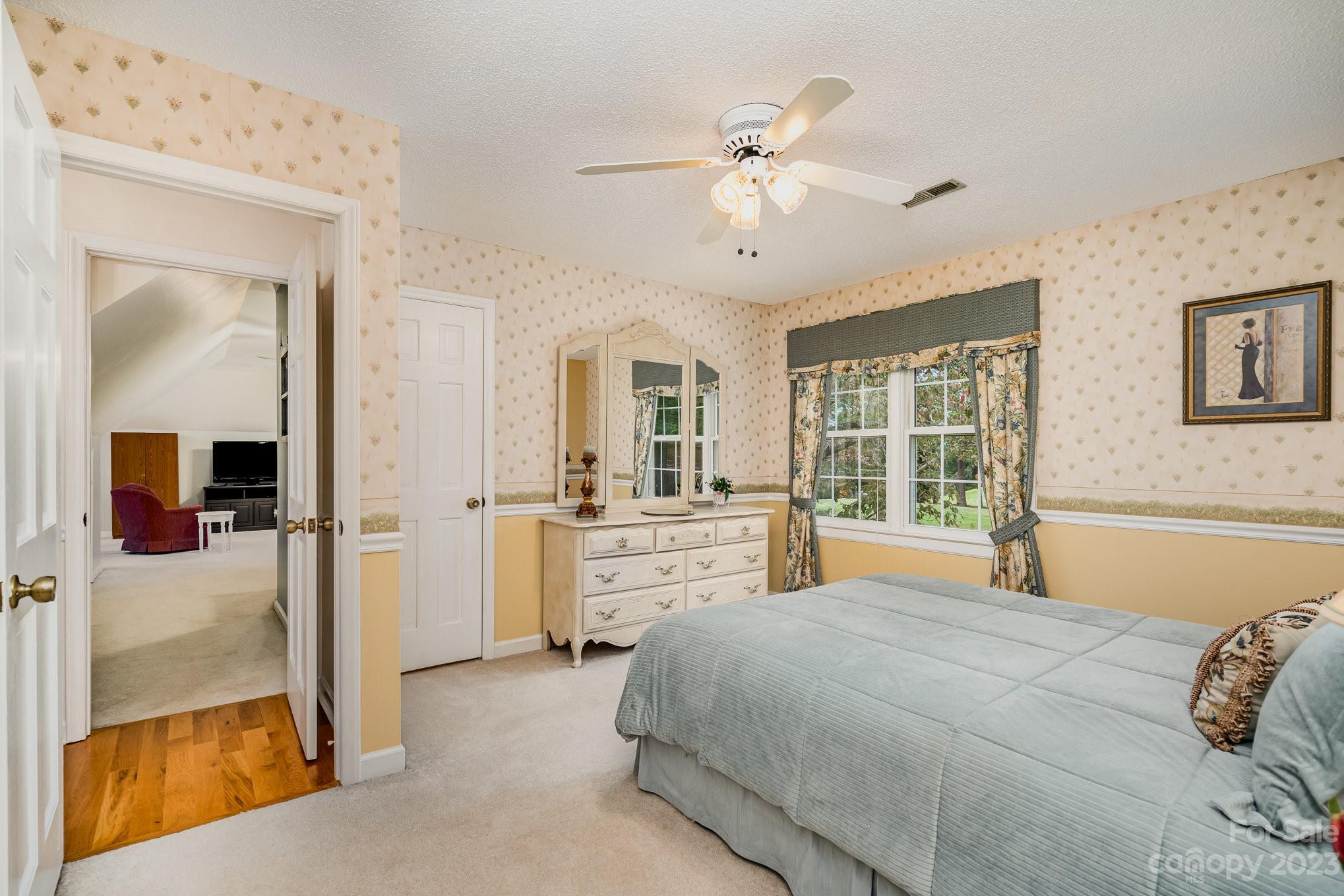 8229 Fairfield Forest Road Denver, NC 28037 - Photo 29 of 41 a bedroom with a large bed and a chandelier