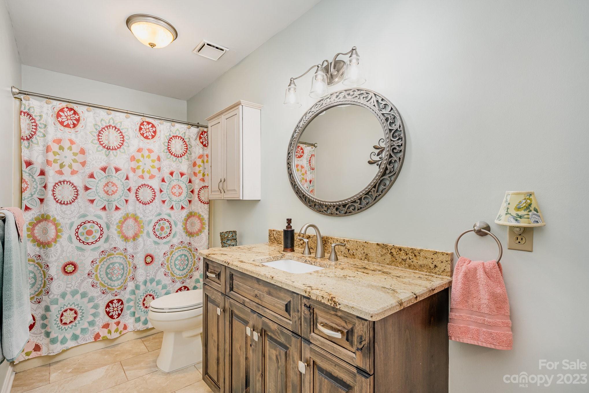 8229 Fairfield Forest Road Denver, NC 28037 - Photo 33 of 41 a bathroom with a granite countertop sink a mirror and a toilet