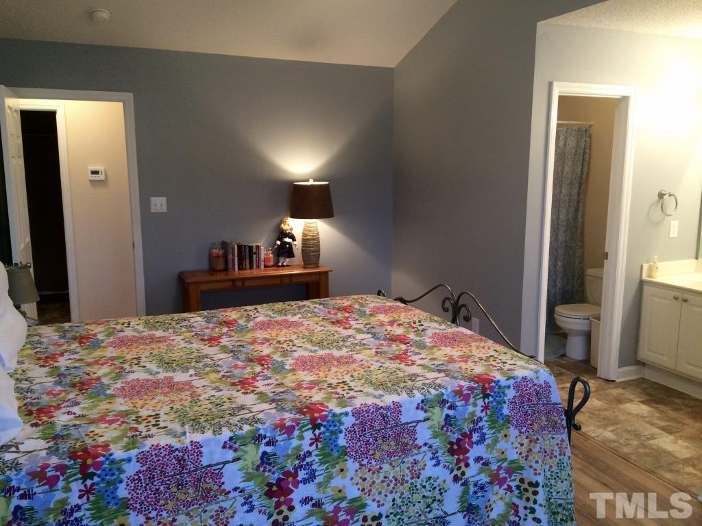 258 Wagner Road Willow Spring, NC 27592 - Photo 12 of 22 a bedroom with a bed and a dresser with mirror