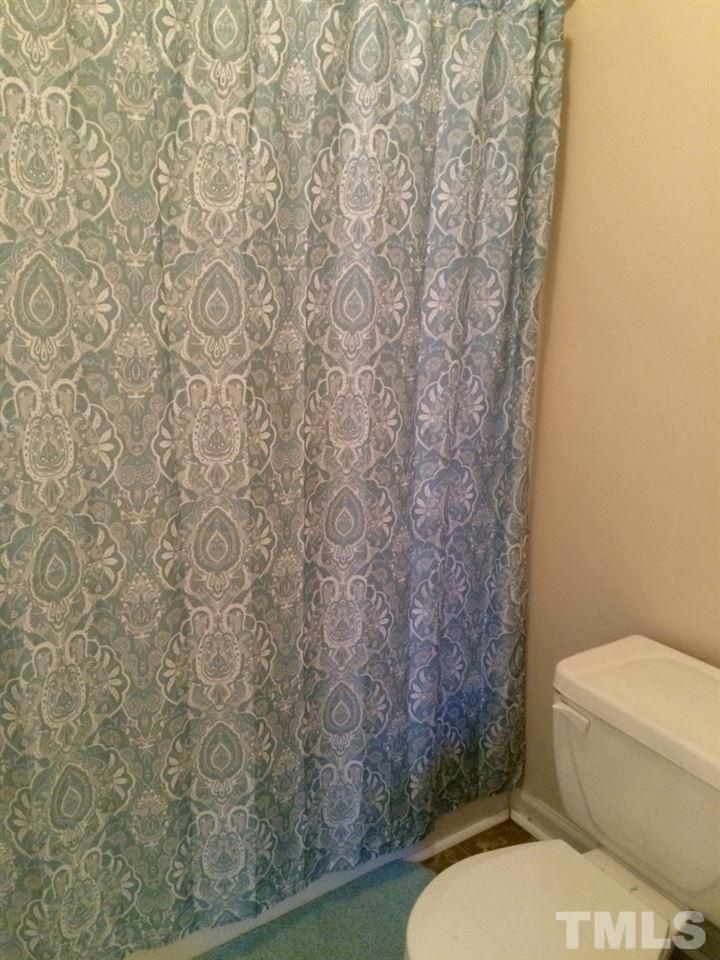 258 Wagner Road Willow Spring, NC 27592 - Photo 14 of 22 a white toilet sitting next to a shower curtain