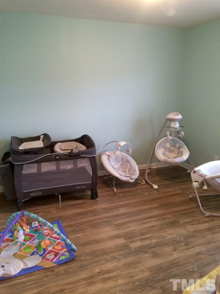 258 Wagner Road Willow Spring, NC 27592 - Photo 16 of 22 a bedroom with bed and a wooden floor