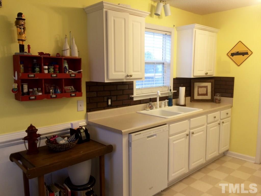 258 Wagner Road Willow Spring, NC 27592 - Photo 8 of 22 a kitchen with a sink cabinets and a stove