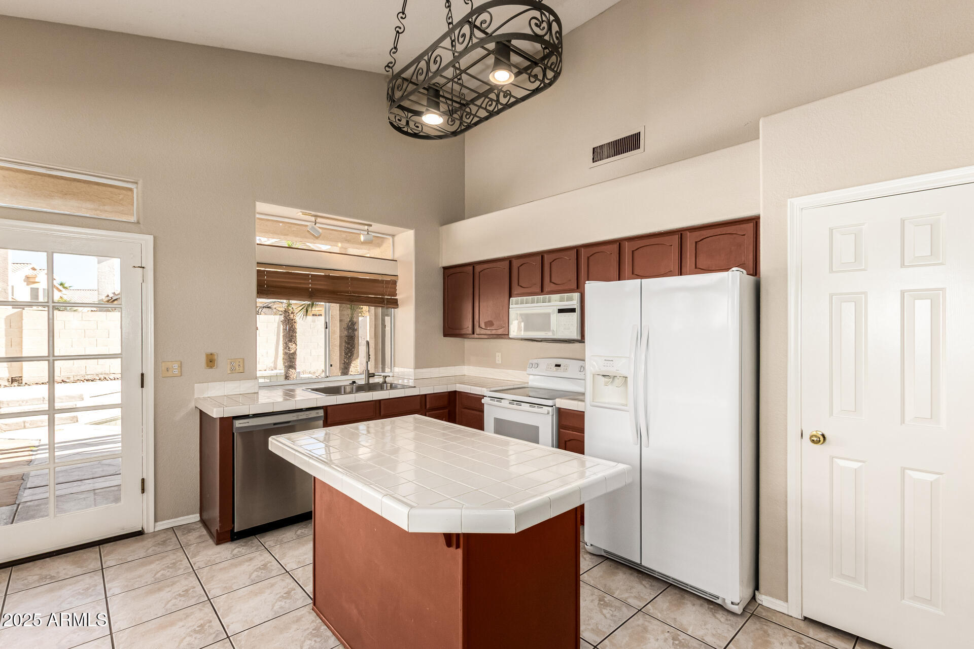 16617 South 14th Street Phoenix, AZ 85048 - Photo 10 of 26 a kitchen with stainless steel appliances chandelier a refrigerator and a stove top oven