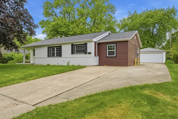 a house with green field in front of it