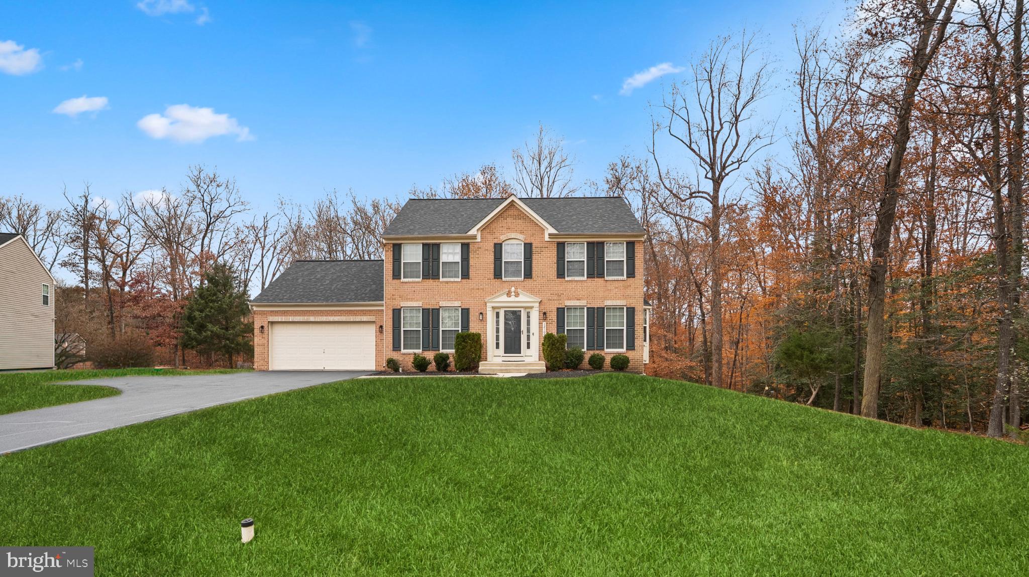 a view of a house with a big yard and large trees