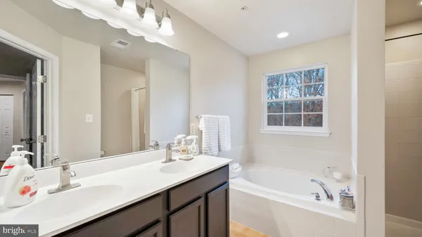a bathroom with a bathtub a sink and a window