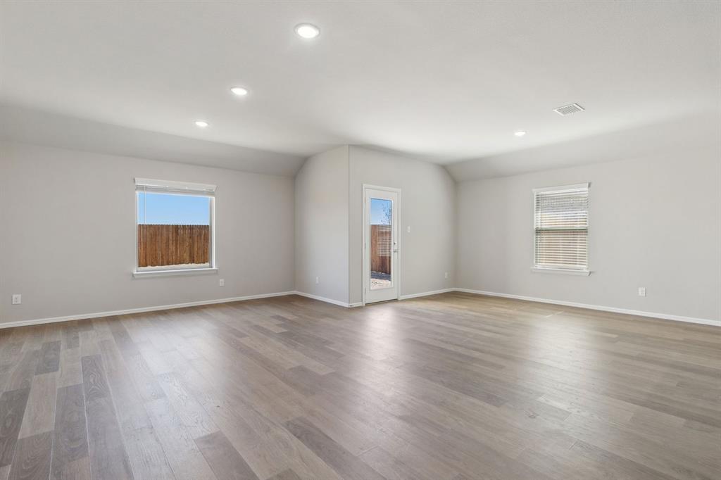 7620 Kingfisher Road Aubrey, TX 76227 - Photo 10 of 32 an empty room with wooden floor and windows