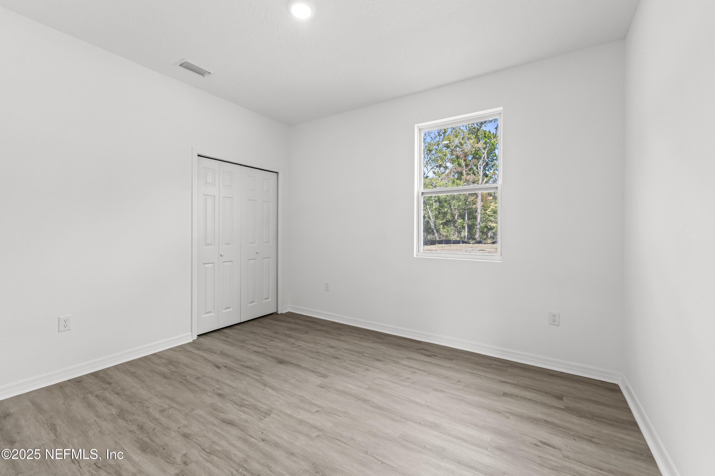 12476 Gate Road Jacksonville, FL 32226 - Photo 21 of 29 an empty room with wooden floor and window