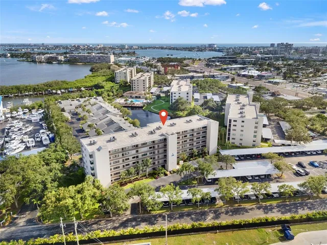 an aerial view of a city with lots of residential buildings ocean and mountain view in back