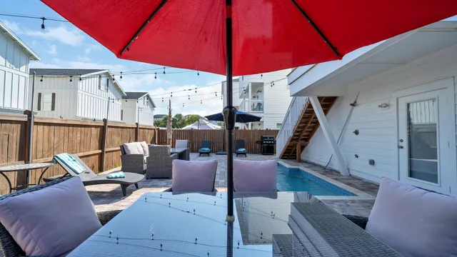 a view of a patio with a table and chairs under an umbrella