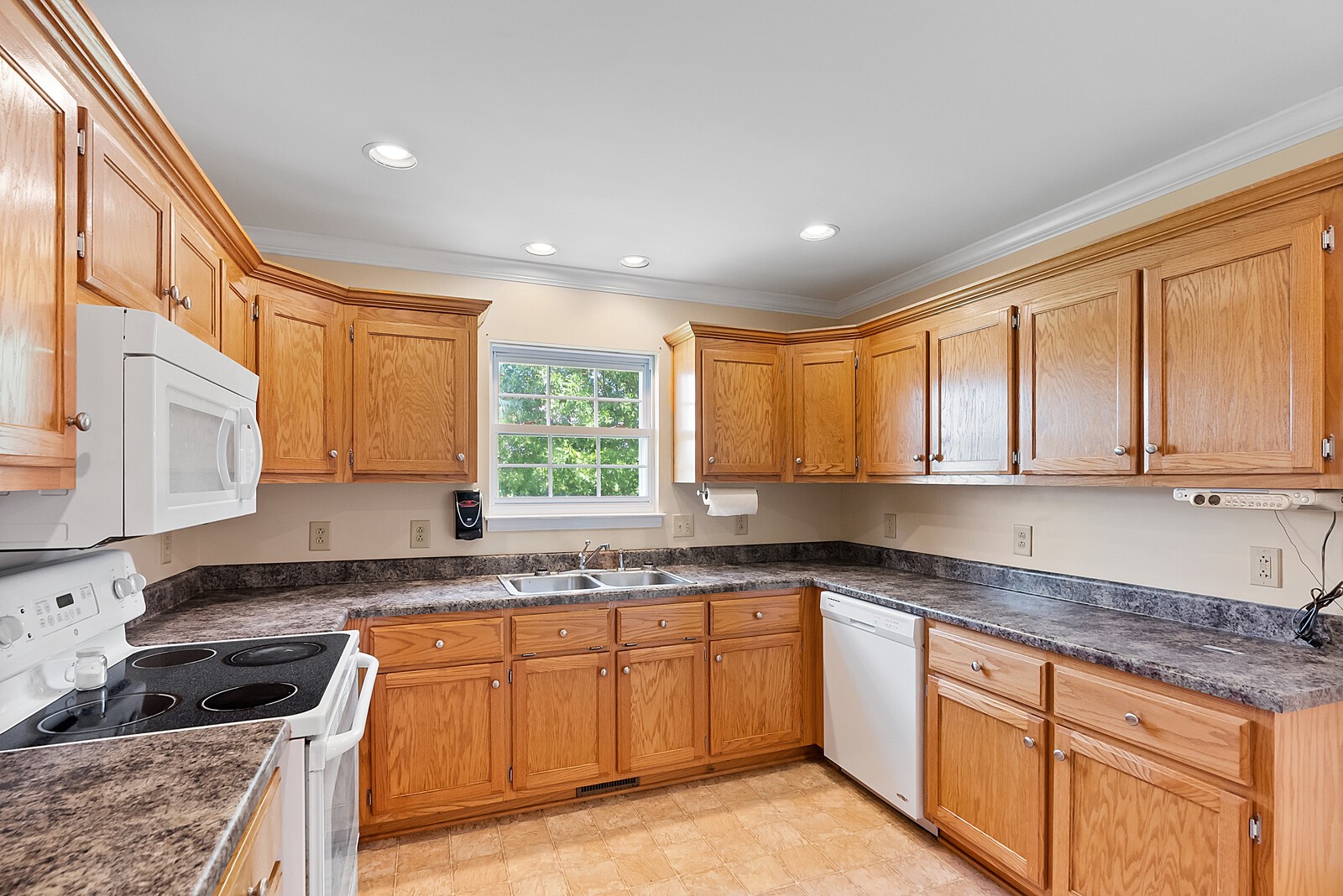 6159 H B Lee Road Springfield, TN 37172 - Photo 17 of 28 a kitchen with granite countertop wooden cabinets a sink a window and stainless steel appliances