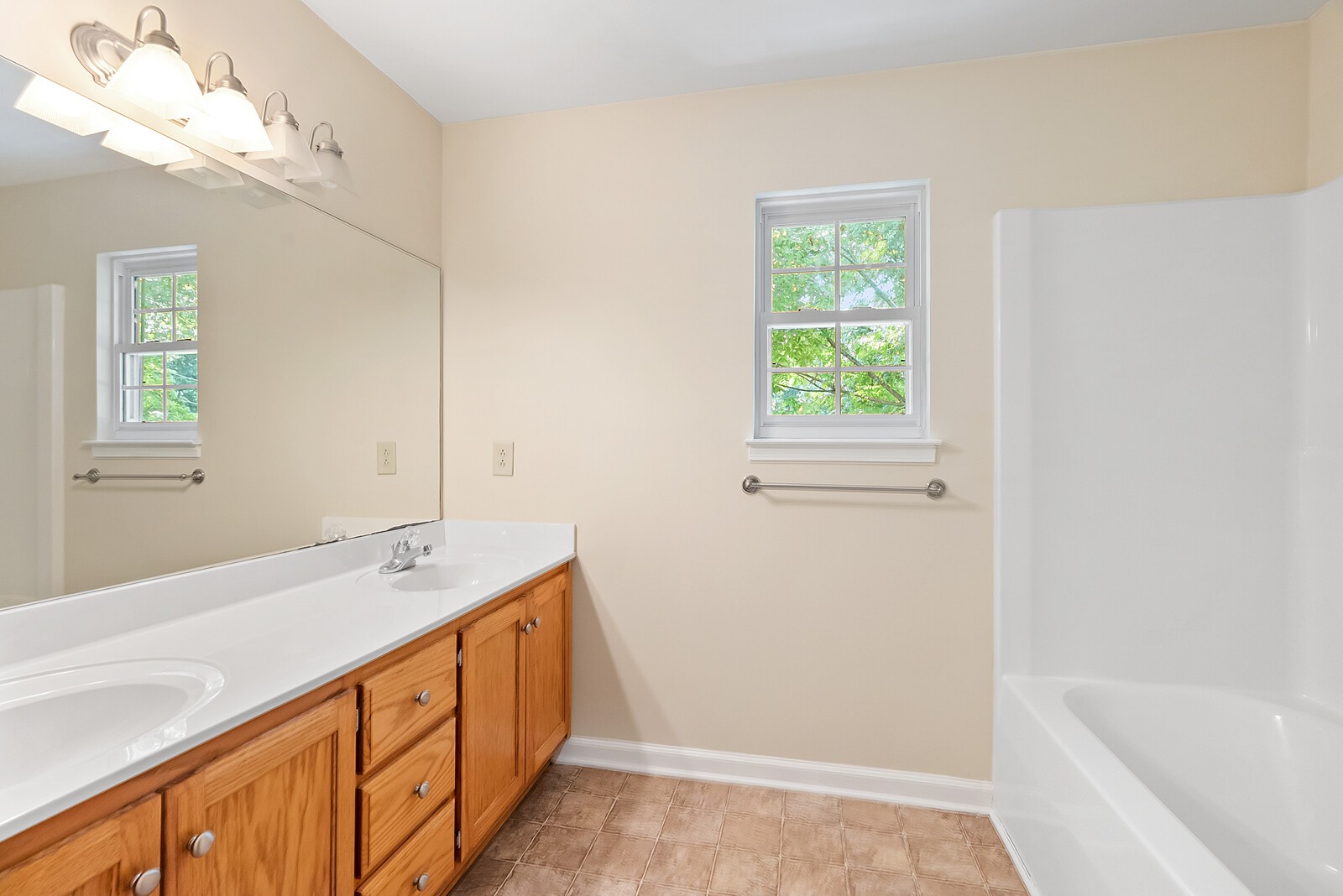 6159 H B Lee Road Springfield, TN 37172 - Photo 10 of 28 a bathroom with a double vanity sink window and a bathtub