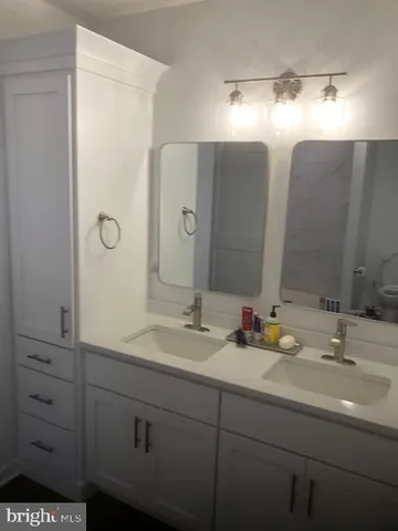 a bathroom with a double vanity sink and a mirror