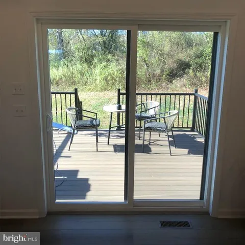 a view of a room with wooden floor and floor to ceiling windows