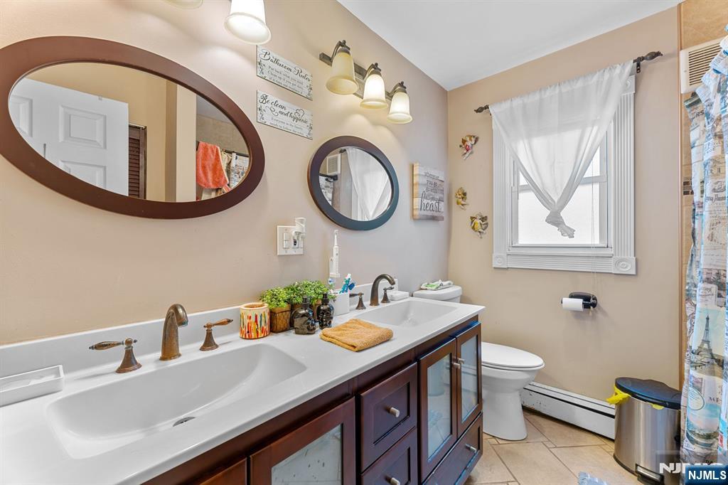 111 East 10th Street Linden, NJ 07036 - Photo 11 of 39 a bathroom with a toilet a sink and mirror