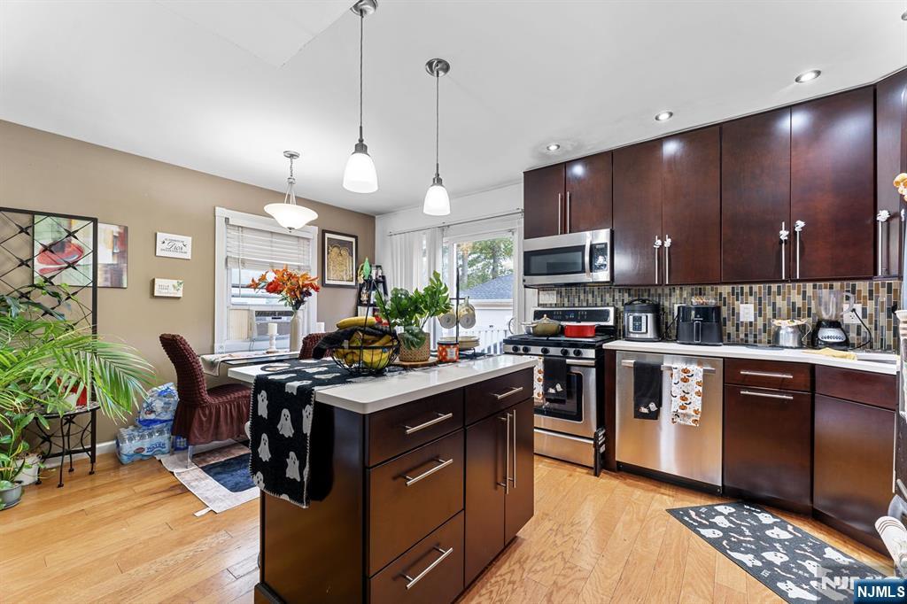 111 East 10th Street Linden, NJ 07036 - Photo 5 of 39 a kitchen with stainless steel appliances granite countertop a stove top oven a sink dishwasher a dining table and chairs with wooden floor