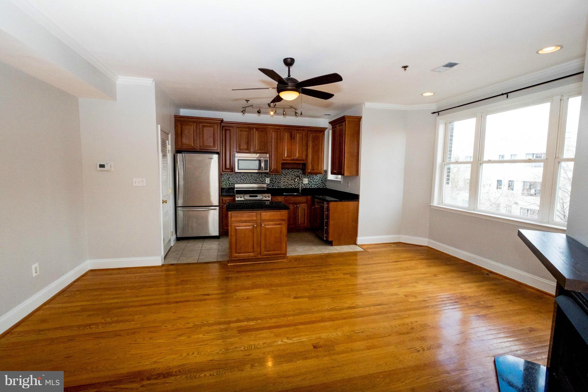 1438 Columbia Road Northwest, Unit 401 Washington, DC 20009 - Photo 3 of 10 a view of an empty room with window and wooden floor