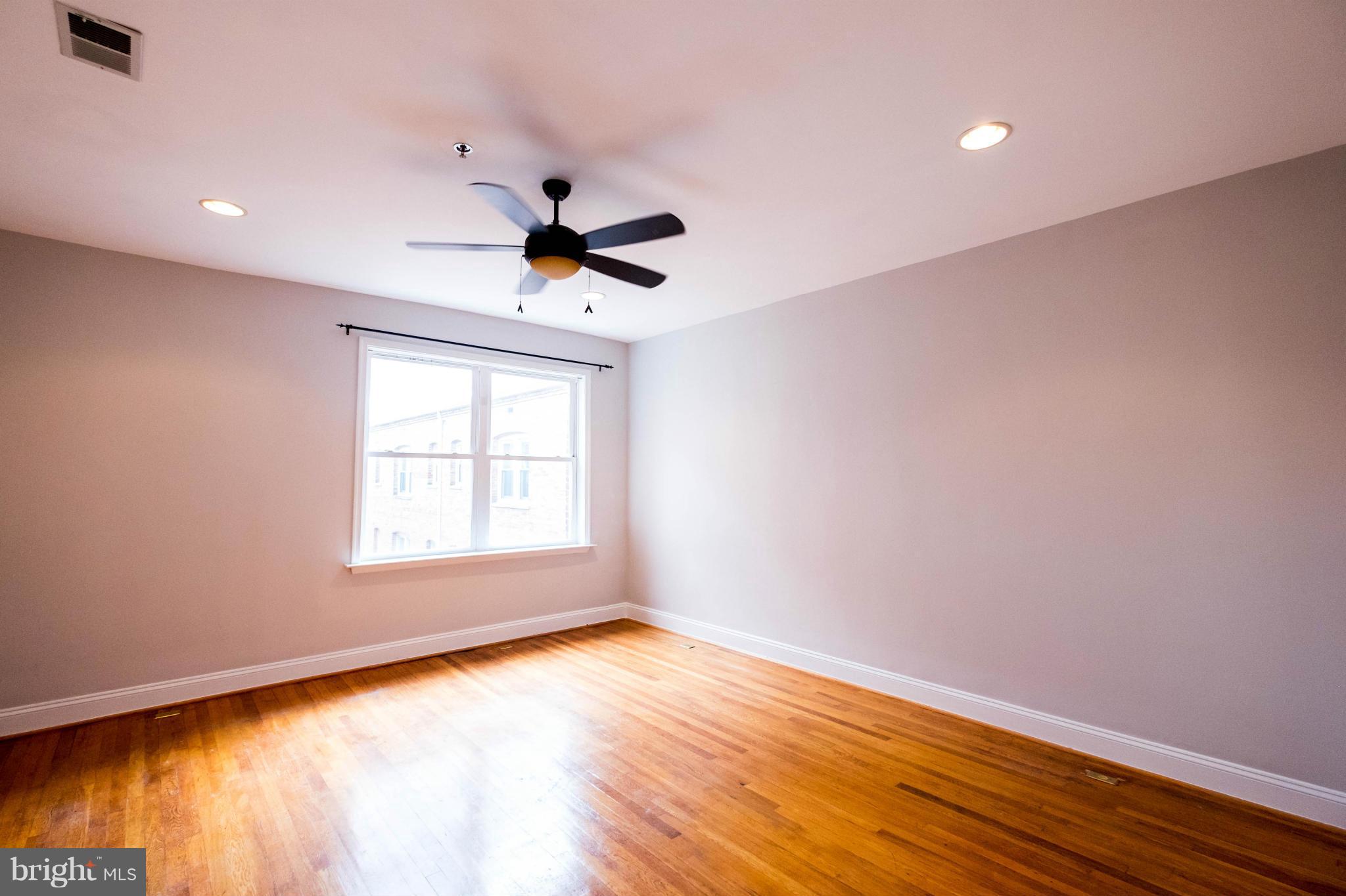 1438 Columbia Road Northwest, Unit 401 Washington, DC 20009 - Photo 5 of 10 wooden floor in an empty room with a window