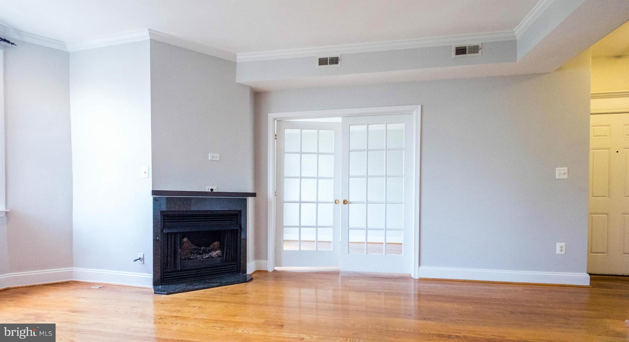 1438 Columbia Road Northwest, Unit 401 Washington, DC 20009 - Photo 7 of 10 a view of an empty room with wooden floor and a window
