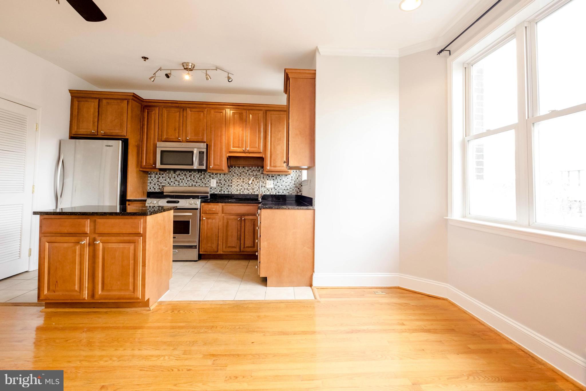 1438 Columbia Road Northwest, Unit 401 Washington, DC 20009 - Photo 8 of 10 a kitchen with stainless steel appliances granite countertop a stove a sink and a refrigerator