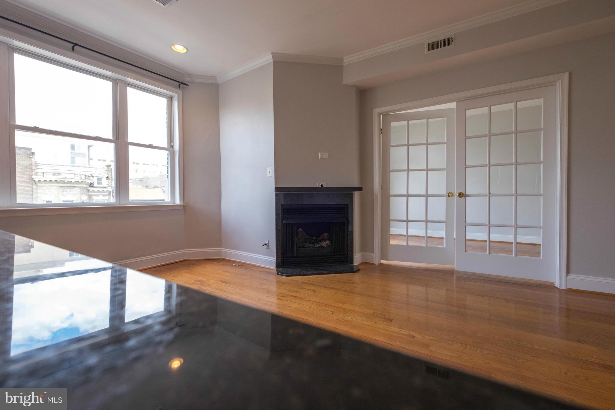 1438 Columbia Road Northwest, Unit 401 Washington, DC 20009 - Photo 9 of 10 a view of an empty room with a window and wooden floor