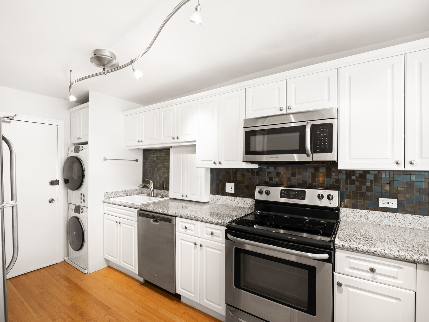 2754 North Hampden Court, Unit 708 Chicago, IL 60614 - Photo 6 of 27 a kitchen with stainless steel appliances granite countertop a stove a sink and a microwave