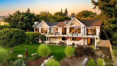 a front view of a house with a garden and lake view