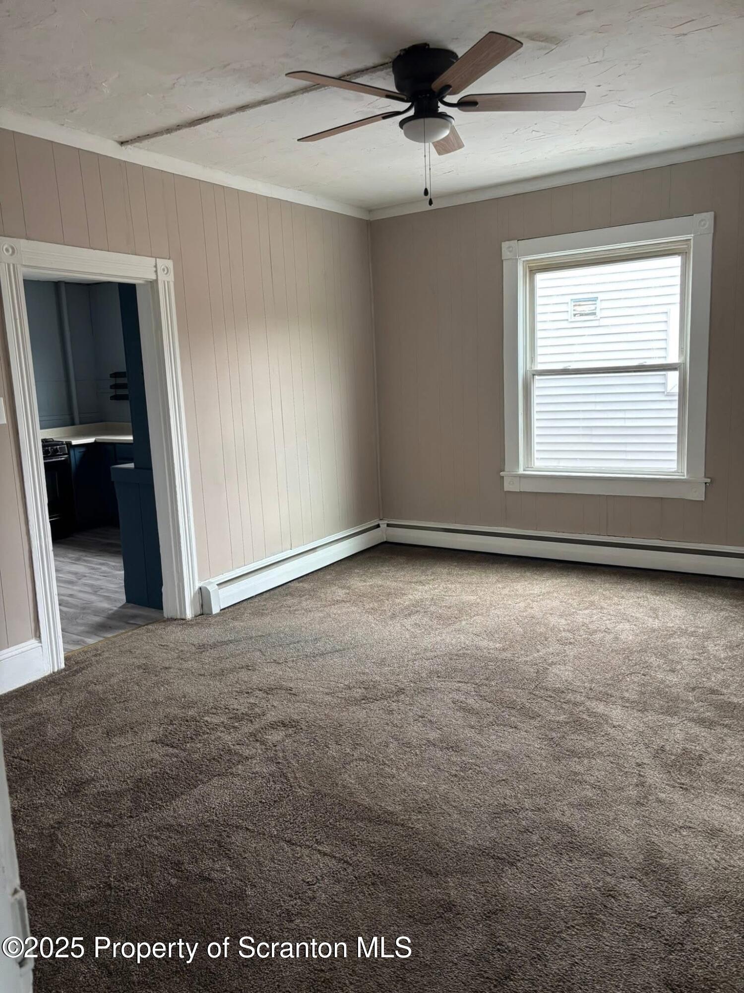210 Center Street, Unit 2 Clarks Summit, PA 18411 - Photo 5 of 14 an empty room with a ceiling fan and window