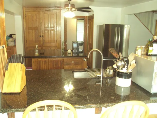 a bathroom with a granite countertop sink a mirror and shower