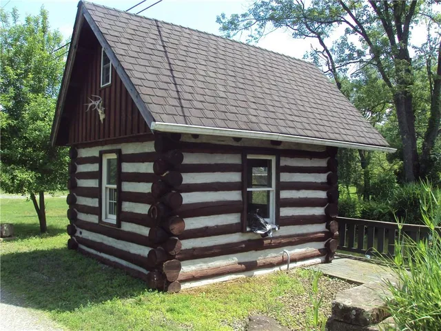 a view of backyard with a deck and wooden fence